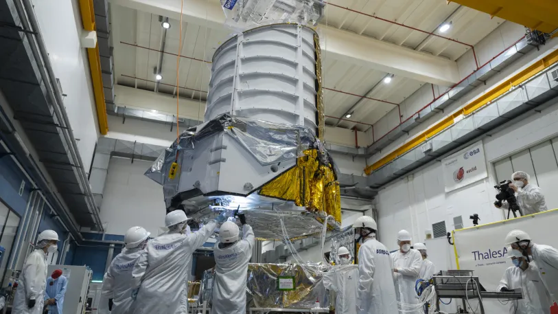 On 24 March 2022, ESA came one step closer to unveiling the mysteries of the dark Universe, following the coming together of two key parts of the Euclid spacecraft – the instrument-carrying payload module and the supporting service module. This image shows the 800-kilogram payload module being lifted by a crane, just before it was lowered onto the service module. Copyright: ESA - S. Corvaja